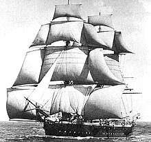 A sailing ship running with the wind, coming toward the observer at an oblique angle, with squaresails and studding sails set on the masts and a headail set from the bowsprit