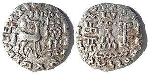 Silver coin of the Kuninda Kingdom, c. 1st century BCE. These coins followed the Indo-Greek module.[1] Obv: Deer standing right, crowned by two cobras, attended by Lakshmi holding a lotus flower. Legend in Prakrit (Brahmi script, from left to right): Rajnah Kunindasya Amoghabhutisya maharajasya ("Great King Amoghabhuti, of the Kunindas"). Rev: Stupa surmounted by the Buddhist symbol triratna, and surrounded by a swastika, a "Y" symbol, and a tree in railing. Legend in Kharoshti script, from right to left: Rana Kunidasa Amoghabhutisa Maharajasa, ("Great King Amoghabhuti, of the Kunindas"). of Kuninda Kingdom