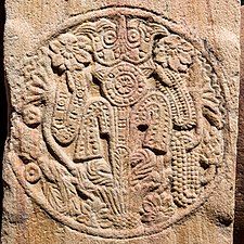 Triratna with decorative scrolls.