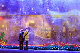 Two girls try to open the first door of an Advent calendar at the Kaiser Wilhelm Memorial Church in Berlin.
