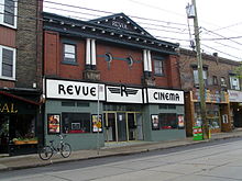 two storey building with large sign Revue Cinema