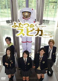 Two young men and three young women in school uniforms standing in front of an astronaut's space suit