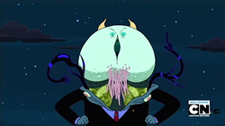 A cartoon demon stands against a starry backdrop. His face is a green mass with a vertical mouth. He is dressed in what appears to be a suit.