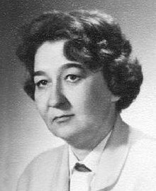 Black and white portrait of a 20th century, middle-aged woman in a light-colored suit and white blouse.