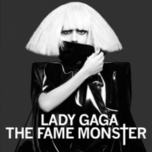 Black-and-white image of Lady Gaga in a blond bob wig with a black collar hiding her mouth.