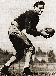 A black and white photo of Case in uniform holding a football