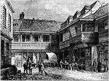 Shortly before its demolition in the 1870s, the Tabard is depicted as a two-storey building with a sloped roof. The upper floor has a loggia supported by columns. A sign on the exterior of the upper floor reads "Old Tabard". The building is set back from a cobbled courtyard, which populated by horses and carriages and surrounded by other similar buildings.
