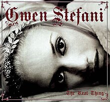 In the cover artwork for "The Real Thing" by Gwen Stefani, her face is shown lying down, with her eyes perpendicular to the ground; her name is in a burgundy-colored font above her, while the song's title is in the same, smaller font in the bottom right corner.