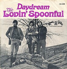 John Sebastian pretends to lay dead while the other three members of the Lovin' Spoonful pose around him like trophy hunters. Zal Yanovsky stands with a foot on Sebastian while holding a rifle.
