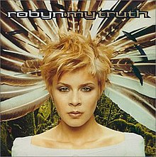 The artwork for the album, featuring a woman (Robyn) with short blonde hair and a large feather headpiece standing in front of a nature background