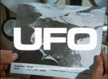 A pair of hands holding a photograph, the letters "UFO" superimposed over it