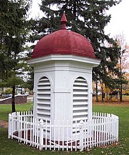 Red-roofed white cupola from the 1927 building, surrounded by a small white picket fence