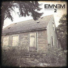 The cover image features Eminem's old childhood home surrounded with trees and grass in rustic filter. On the top right corner, the album title and artist name appears.