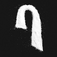 Salt is sprinkled across a black background, forming Max's signature haircut logo. There is no text on the cover.
