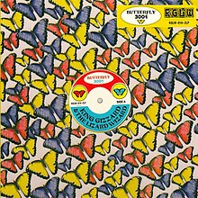 A background of red, blue, and yellow butterflies oriented horizontally to the top left corner, with a KGLW label in the top right corner, and a vinyl disc label for the album in the middle.