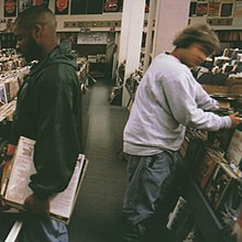 Two men look through vinyl records at a record store.