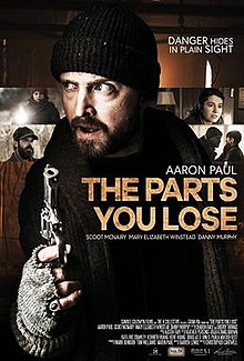 Aaron Paul in character with heavy clothing and a gun, framed by four screenshots of other characters in the film.
